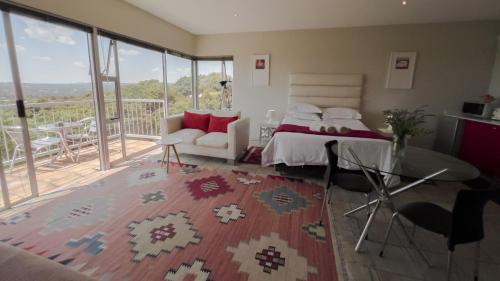 a bedroom with a bed and a balcony at Orangerie Guest House in Johannesburg
