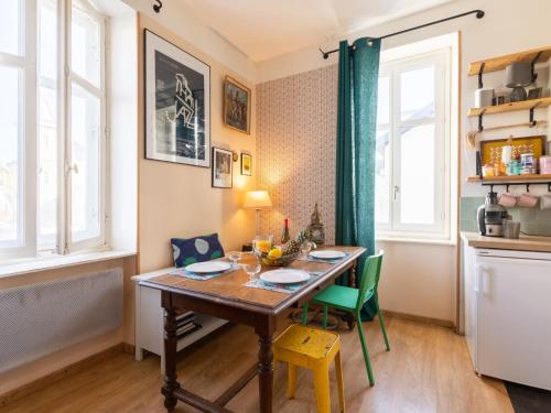 une salle à manger avec une table en bois et des chaises vertes dans l'établissement Apartment Haitze Egoa by Interhome, à Biarritz