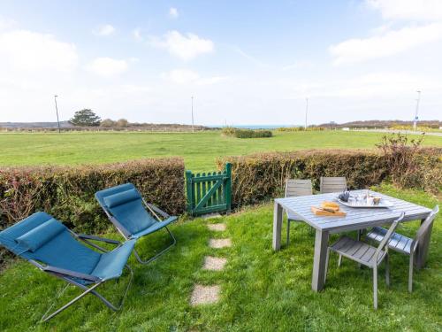 a table and chairs in the grass with a field at Apartment La Baie des Corsaires-8 by Interhome in Saint Malo