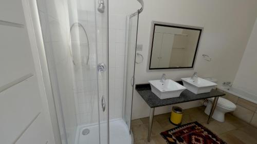 a bathroom with two sinks and a shower at Orangerie Guest House in Johannesburg