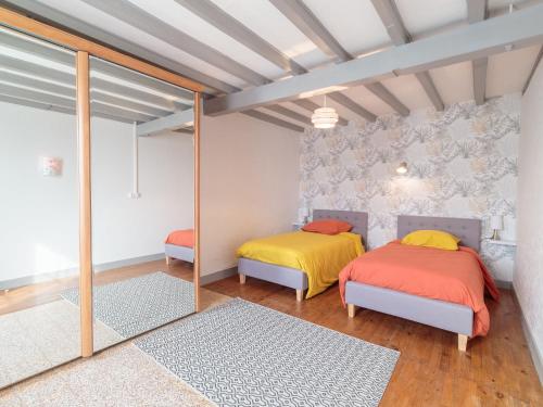 deux lits dans une chambre avec un miroir dans l'établissement Holiday Home Gîte La Truffière Saintongeaise by Interhome, à Berneuil