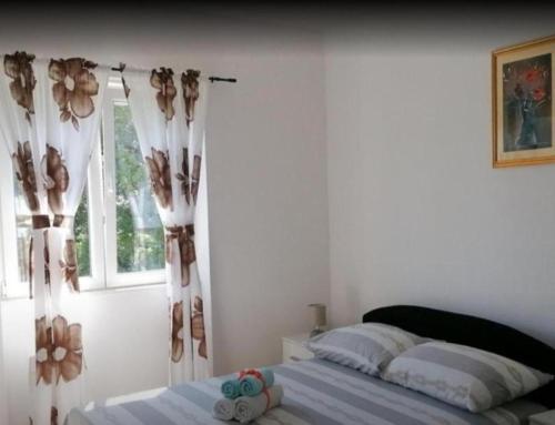 a bedroom with a bed and a window at Apartment Antea - private parking & garden in Čilipi