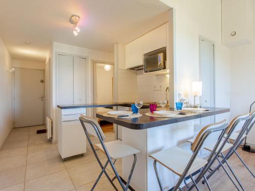 een keuken met een aanrecht en stoelen in een kamer bij Apartment Les Bourdaines by Interhome in Seignosse