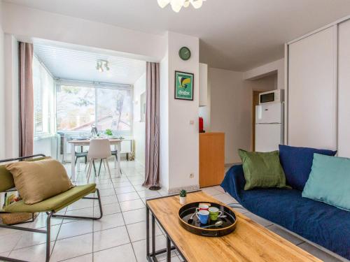 un salon avec un canapé bleu et une table dans l'établissement Apartment La Louisiane by Interhome, à Capbreton