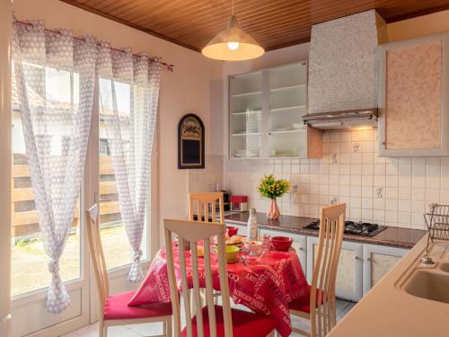 kuchnia i jadalnia z czerwonym stołem i krzesłami w obiekcie Holiday Home La Gare by Interhome w mieście Mimizan