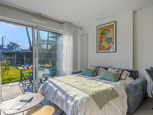 une chambre avec un lit et une porte coulissante en verre dans l'établissement Apartment Les Villas du Men Du-3 by Interhome, à Carnac