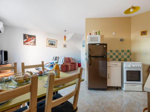 une cuisine et une salle à manger avec une table et un réfrigérateur dans l'établissement Holiday Home L'Abrivado by Interhome, à Aigues-Mortes