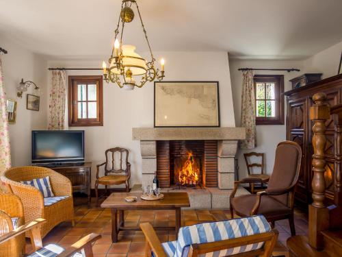 un salon avec une cheminée et une télévision dans l'établissement Holiday Home Saint Nicolas by Interhome, à Névez