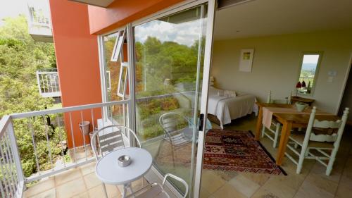 a room with a balcony with a table and chairs at Orangerie Guest House in Johannesburg