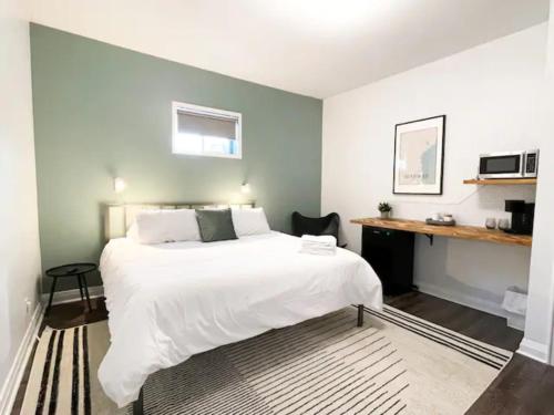 a bedroom with a large white bed and a desk at Lake Superior Boutique Hotel in Thunder Bay