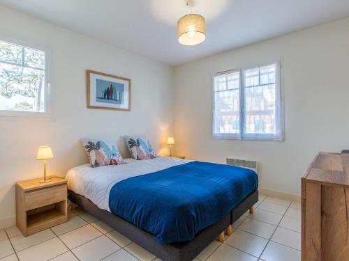 - une chambre avec un lit doté de draps bleus et 2 fenêtres dans l'établissement Apartment Les Berges Landaises-5 by Interhome, à Capbreton