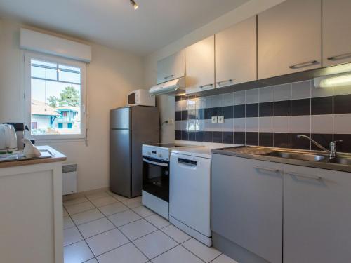 une grande cuisine avec des appareils électroménagers blancs et une fenêtre dans l'établissement Apartment Les Berges Landaises-5 by Interhome, à Capbreton