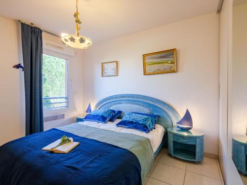 une chambre avec un lit bleu et une fenêtre dans l'établissement Apartment Le Grand Parc-10 by Interhome, à Saint-Aygulf