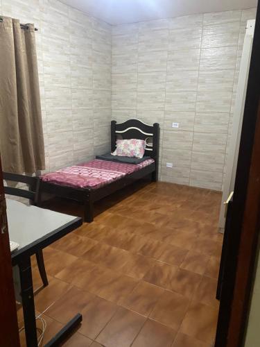 een kleine kamer met een bed en een houten vloer bij República da Luh in Sao Paulo