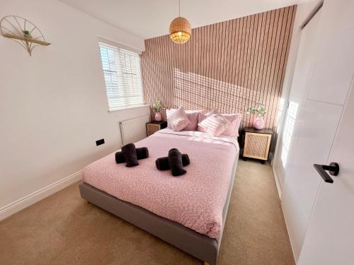 a bedroom with a pink bed with two black teddy bears on it at Cosy 2 Bed Apartment Minutes From Bournemouth Beach & Town in Bournemouth