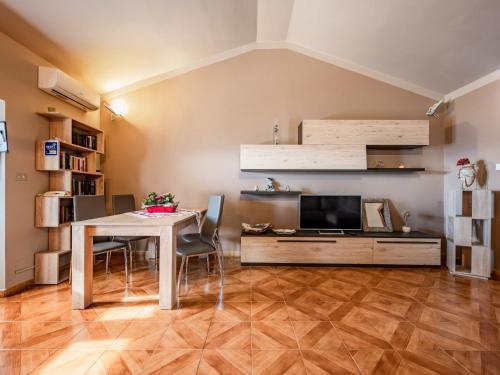 een woonkamer met een tafel en een televisie bij Apartment Emilia Guest House by Interhome in Agliano Terme
