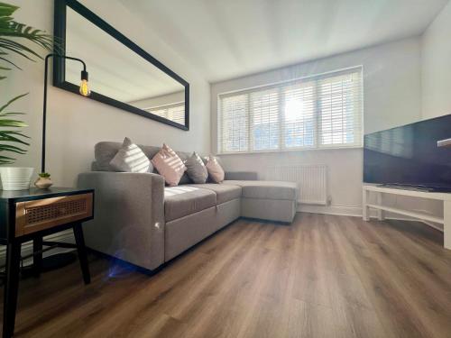 a living room with a couch and a flat screen tv at Cosy 2 Bed Apartment Minutes From Bournemouth Beach & Town in Bournemouth