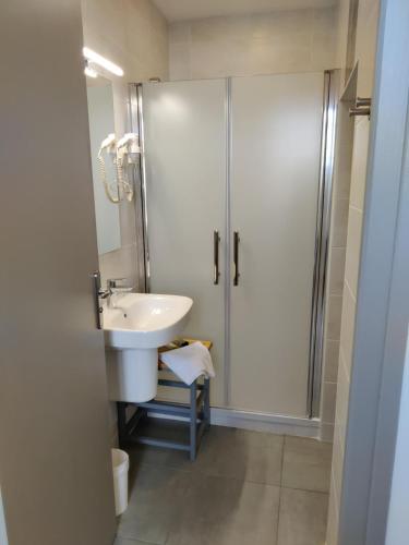 a bathroom with a sink and a shower at Hôtel Océan Dinan in Dinan