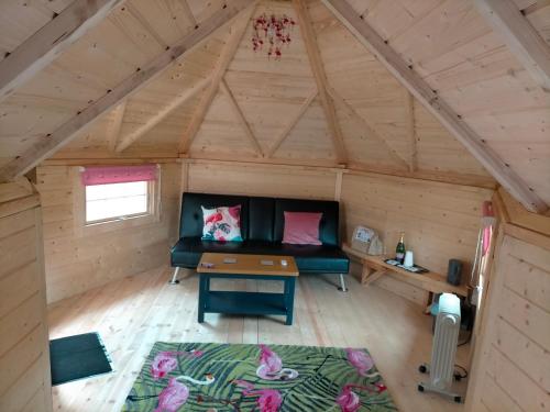a living room of a log cabin with a couch and a table at Oak Tree Escape in Brome
