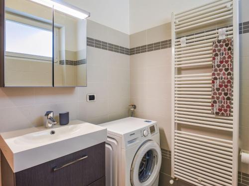 a bathroom with a washing machine and a sink at Apartment Nr- 33 by Interhome in Consiglio di Rumo