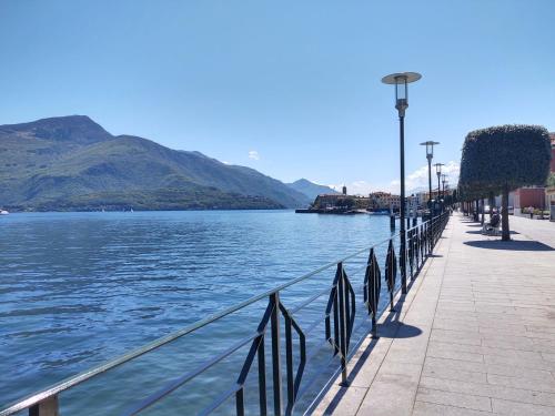 a walkway next to a body of water with mountains at Apartment Nr- 33 by Interhome in Consiglio di Rumo
