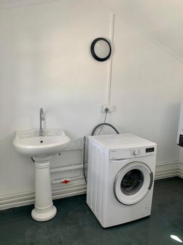 a washing machine in a bathroom next to a sink at Serenity apartments in Trou aux Biches