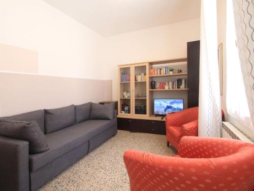 ein Wohnzimmer mit einem Sofa, 2 Stühlen und einem TV in der Unterkunft Holiday Home Villa Emma by Interhome in Forte dei Marmi