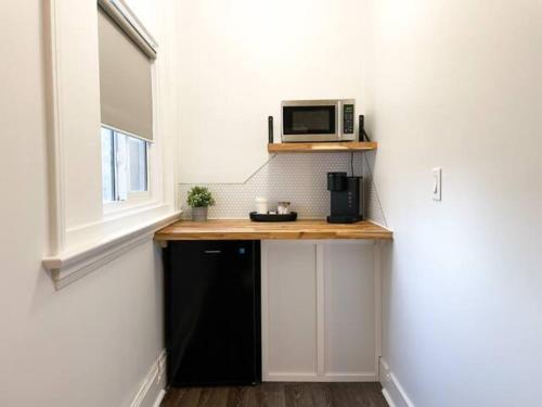 a small kitchen with a counter with a microwave on it at Lake Superior Boutique Hotel in Thunder Bay