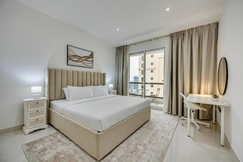 1 dormitorio con cama, escritorio y ventana en Bright stylish sea view apartment in JBR, en Dubái