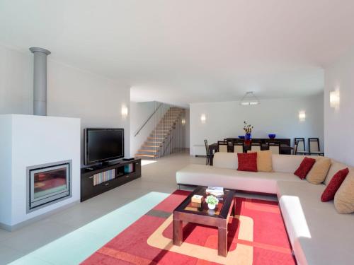 a living room with a white couch and a fireplace at Villa Almond Tree by Interhome in Porches