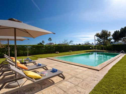 a swimming pool with two lounge chairs and an umbrella at Villa Almond Tree by Interhome in Porches