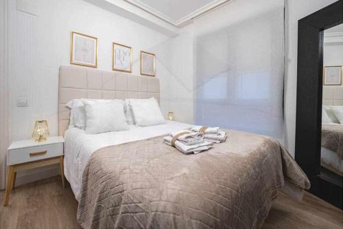 a white bedroom with a large bed with a tray on it at La Muralla centro Oviedo in Oviedo