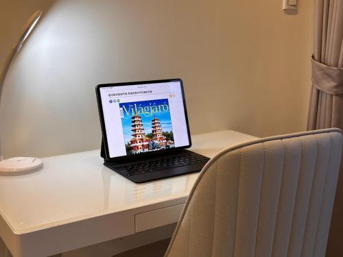 um computador portátil sentado em cima de uma secretária em Luxury Studio in the vibrant Kaohsiung Arena MRT em Kaohsiung
