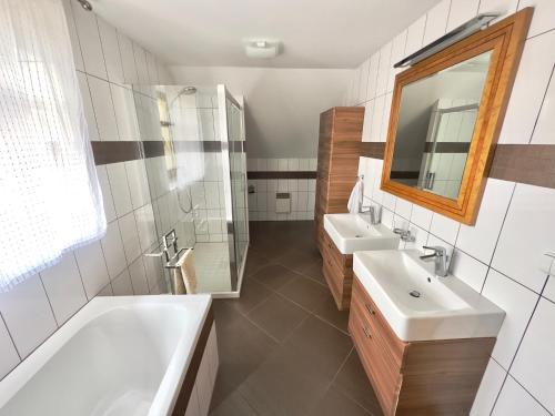 a bathroom with two sinks and a shower and a mirror at Dům u koupaliště in Česká Kamenice
