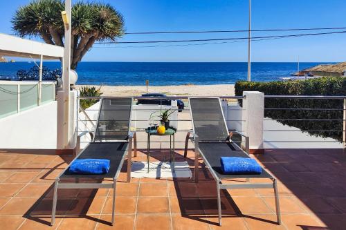 a patio with a table and chairs and the beach at San Luis in Jávea