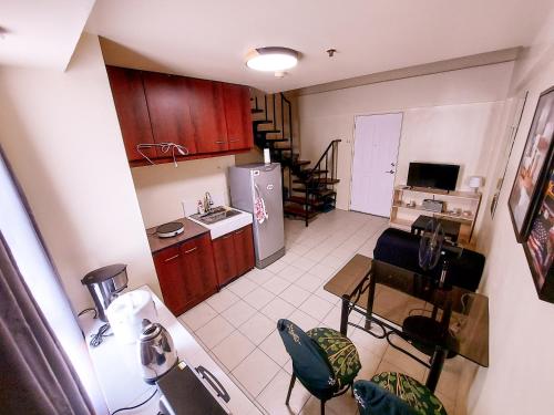 an overhead view of a kitchen with a table and chairs at Affordable Cozy and Peaceful Loft Condo near Cubao in Manila