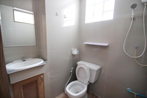 La salle de bains est pourvue de toilettes et d'un lavabo. dans l'établissement Sakun Place, à Bangna
