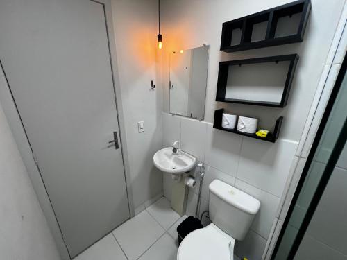 La salle de bains blanche est pourvue de toilettes et d'un lavabo. dans l'établissement Apartamento 4 andar Completo em Condomínio Residencial Familiar, à Porto Velho