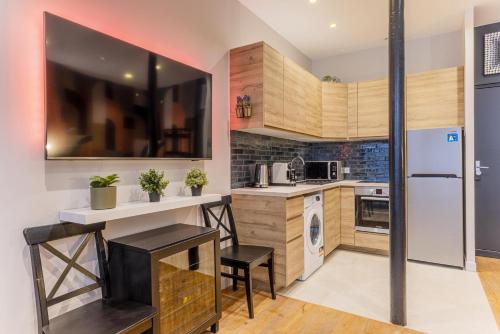 une cuisine avec des armoires en bois et un réfrigérateur blanc dans l'établissement Spacious apartement - 4BR-10P - Paris Center, à Paris