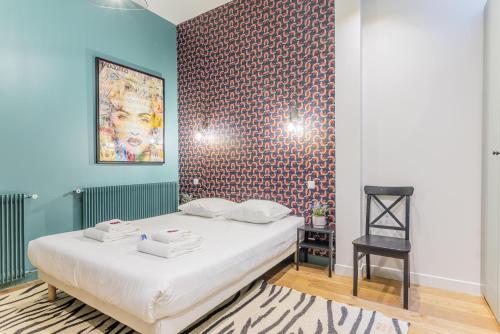 une chambre avec un lit et un mur bleu dans l'établissement Spacious apartement - 4BR-10P - Paris Center, à Paris