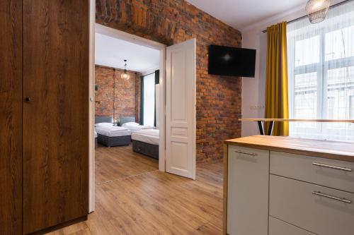 a kitchen and living room with a brick wall at Big flat for groups - for 13 pax, 100sq in Krakow