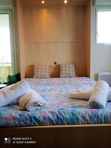 une chambre avec un grand lit avec des oreillers dessus dans l'établissement Appartement proche plage, à Saint-Nazaire