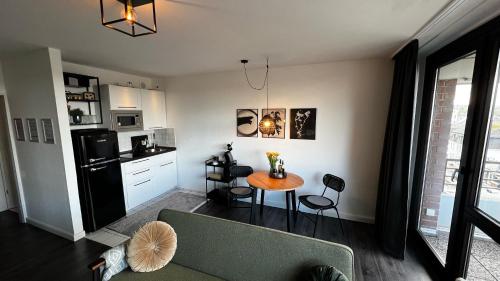 a living room with a table and a kitchen at BOSTEL 54 - Apartment, Altstadt, Aufzug, Hunde willkommen in Moers
