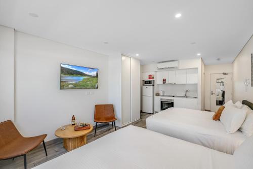 a bedroom with two beds and a table and chairs at The Merchant Hotel in Sydney
