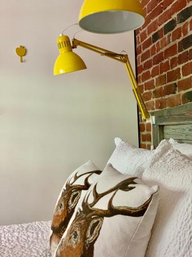a yellow lamp sitting on top of a bed at Vakantiehuis ABEL in Dilsen-Stokkem