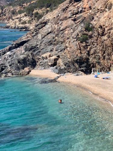 a person swimming in the water near a beach at L'angolo di Filo in Teulada
