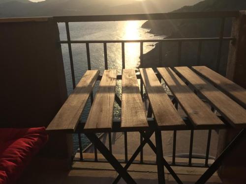 a wooden picnic table on a balcony with the ocean at L'angolo di Filo in Teulada