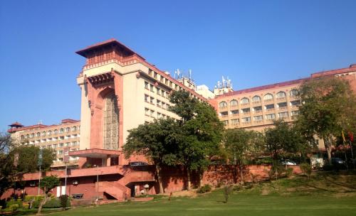 a large building with a clock tower in front of it at The Ashok, New Delhi in New Delhi