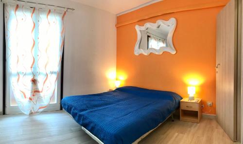 a bedroom with a blue bed and a window at Villaggio Tivoli in Bibione