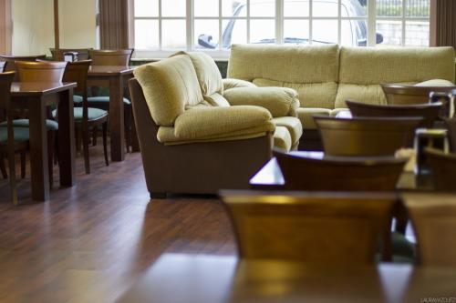 a living room with a couch and tables and chairs at As Areas II in Viveiro